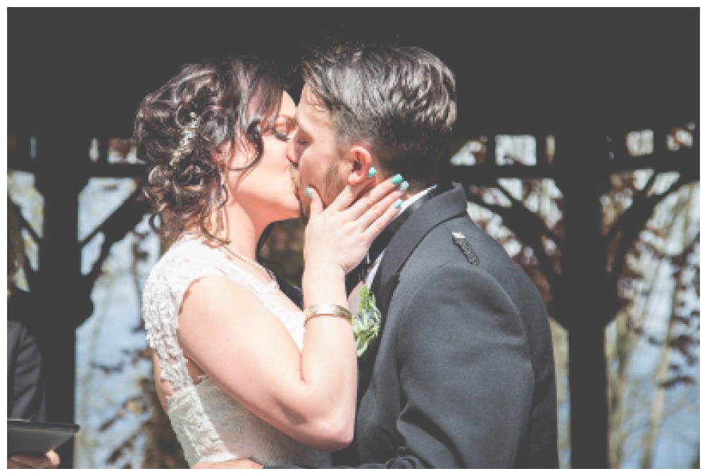 Bride pulls groom in for their fist kiss as married couple