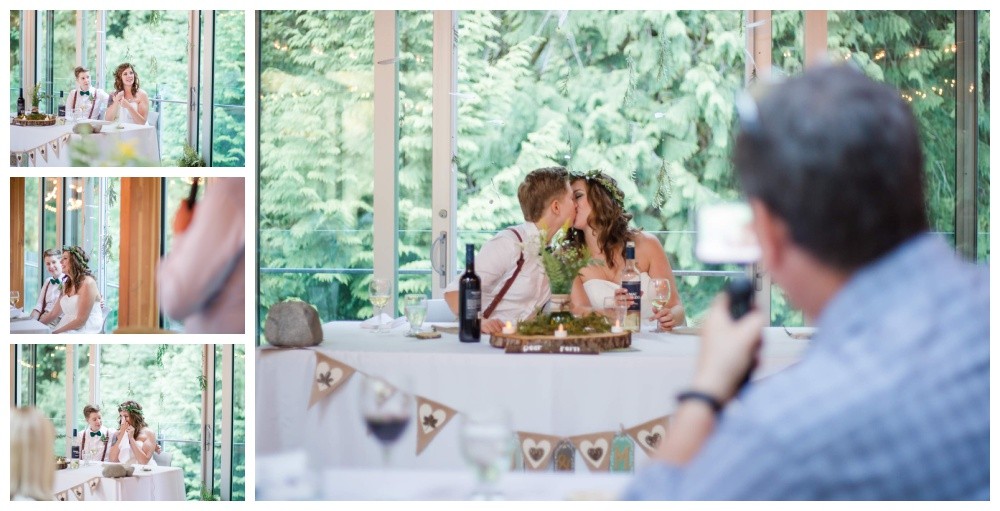 Brides kiss at their head table after their forest wedding 