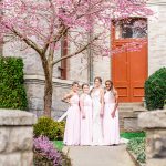 Bride and bridesmaids pose for group photo under a blossoming cherry tree in downtown Victoria BC